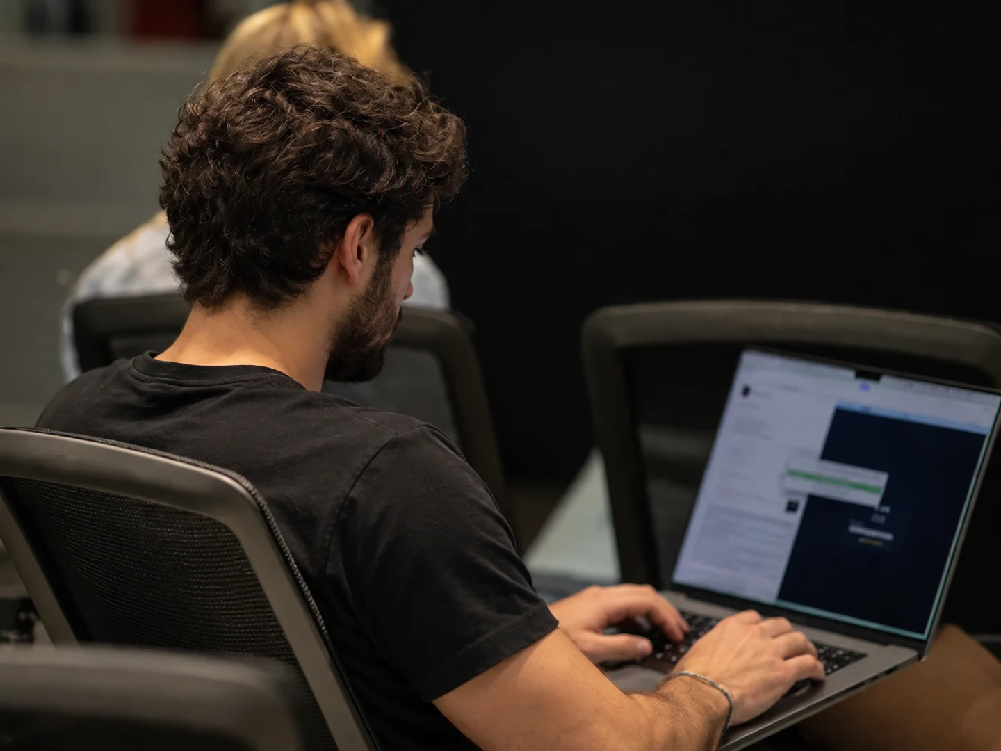 A creator working on his laptop in a shared workspace